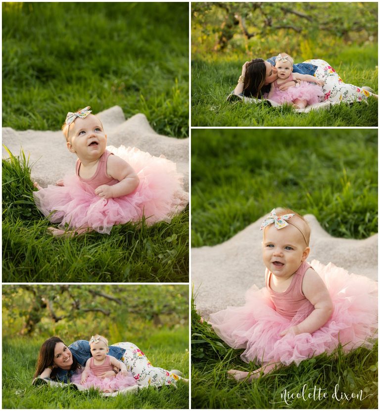 Baby girl wearing pink tutu plays in grass with mother in Soergel Orchards near Pittsburgh