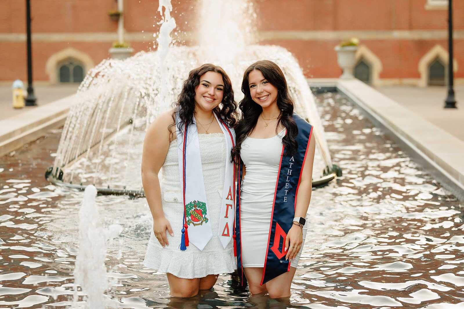 College graduates standing in fountain at Duquesne University in Pittsburgh